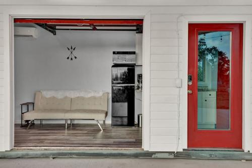 a couch sitting on a porch next to a red door at Best little Fredericksburg Bed and Breakfast Unit2 in Fredericksburg