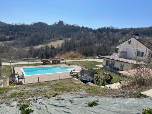une maison avec une piscine en face d'une maison dans l'établissement Agriturismo Ippocastano, à Sciolze