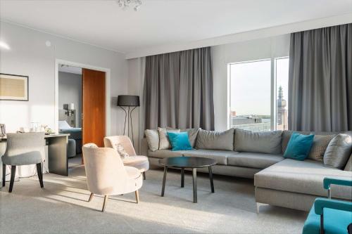 a living room with a couch and chairs and a table at Best Western Plus Hotel Plaza in Västerås