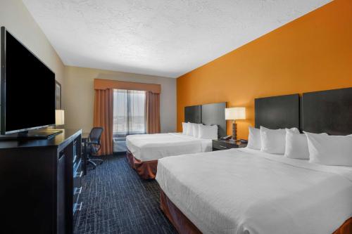 a hotel room with two beds and a flat screen tv at Best Western Plus North Platte Inn & Suites in North Platte