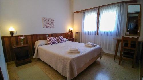sypialnia z łóżkiem z dwoma ręcznikami w obiekcie Hotel Meson w mieście Pinamar