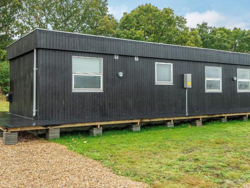 a black house sitting on a wooden platform at 5 person holiday home in Ansager-By Traum in Ansager