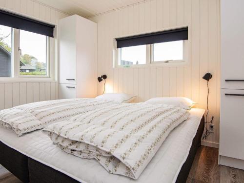 a bedroom with a large white bed with two windows at Holiday home Haderslev XLVII in Haderslev