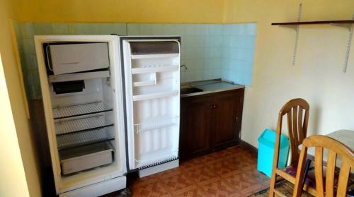 una nevera vacía con la puerta abierta en una cocina en Casa de Huespedes Concordia en Cochabamba
