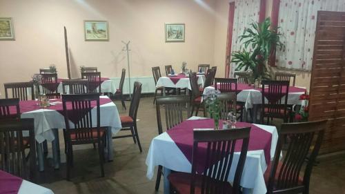 a dining room with tables and chairs with red and purple tablecloths at Lugarnica in Zagreb