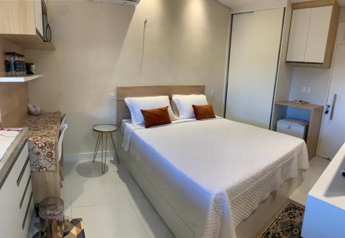 ein kleines Schlafzimmer mit einem weißen Bett mit zwei Kissen in der Unterkunft Suíte ACONCHEGO no Villa do porto a 300m do Beach Park e a 5 minutos a pé da praia in Aquiraz