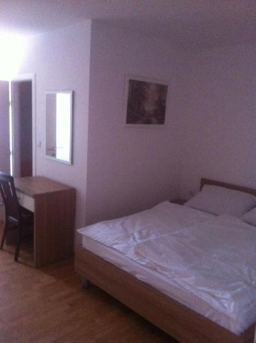 a bedroom with a bed and a desk and a table at Lugarnica in Zagreb