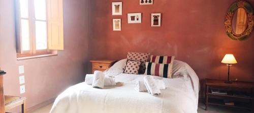 Schlafzimmer mit einem Bett mit weißer Bettwäsche und Kissen in der Unterkunft La Elegida in Tilcara