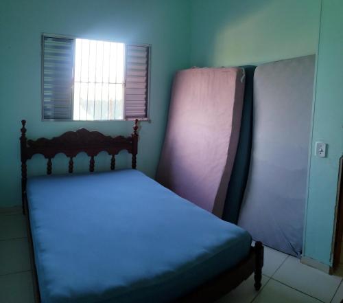 Bett in einem Zimmer mit Fenster in der Unterkunft Casa Pestana - Ilha Comprida in Ilha Comprida