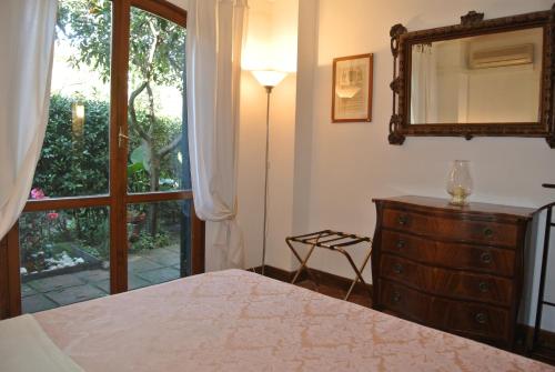 a bedroom with a bed and a dresser and a window at The Palatine Garden Apartment in Rome