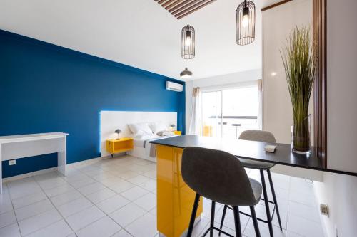 een blauwe en witte kamer met een tafel en stoelen bij Lumina - DestinationGuyane - Séjours d'affaires - Services personnalisés in Cayenne