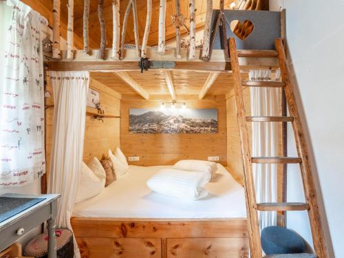- un lit dans une cabane dans les arbres avec une échelle dans l'établissement Maier Alm, à Wald im Pinzgau