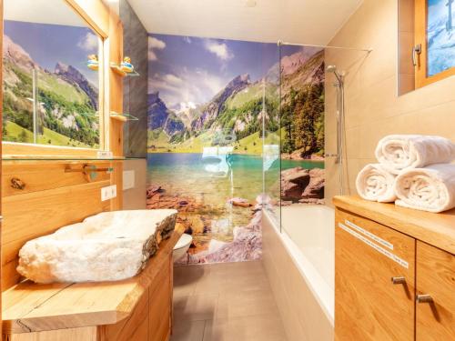 La salle de bains est pourvue d'une douche et d'une fresque murale de montagne. dans l'établissement Maier Alm, à Wald im Pinzgau