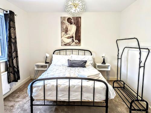 a bedroom with a wrought iron bed and a chandelier at Lovely 3 Bed Home for Colleagues in Darlington