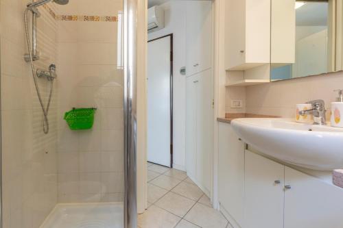 een witte badkamer met een wastafel en een douche bij Apartment Holiday Senigallia in Senigallia