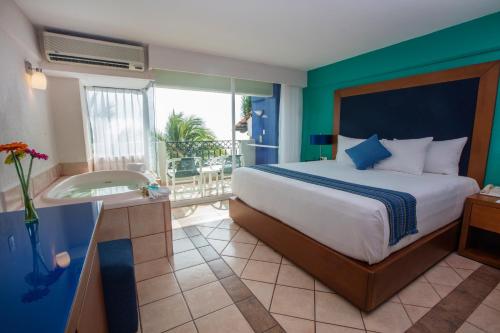 a bedroom with a large bed and a balcony at Crown Paradise Golden All Inclusive Resort - Adults Only in Puerto Vallarta