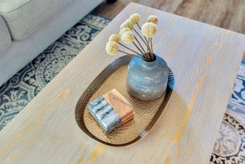 a table with a blue vase with flowers and a book at Rosé Getaway Close to Downtown Paso Robles 2 Bed/1 Bath in Paso Robles