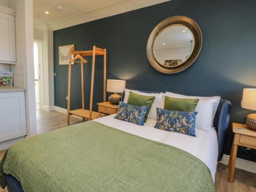 een slaapkamer met een groot bed met een spiegel aan de muur bij Fenby Suite in Saltburn-by-the-Sea