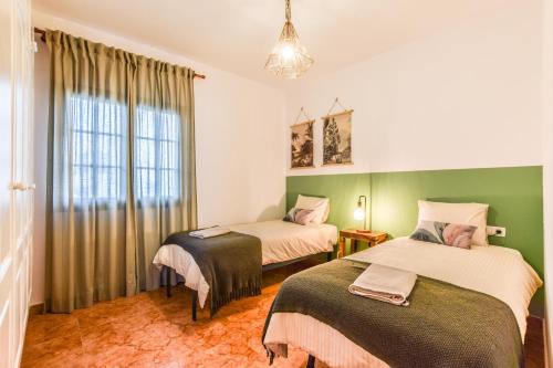 2 Betten in einem Zimmer mit grünen Wänden in der Unterkunft Ca´ Lita in Playa Blanca