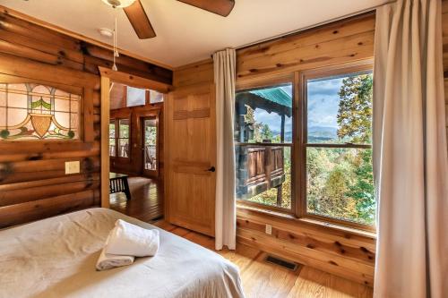 Un dormitorio con una cama y una ventana grande en Alpine Splendor Family Game Room Views Hot Tub, en Sevierville