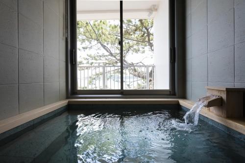 una piscina de agua en una habitación con ventana en THE HARBOR TERRACE, en Kotsubo