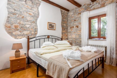 a bedroom with a bed with a stone wall at Apartments and rooms with parking space Loborika, Pula - 12983 in Marčana