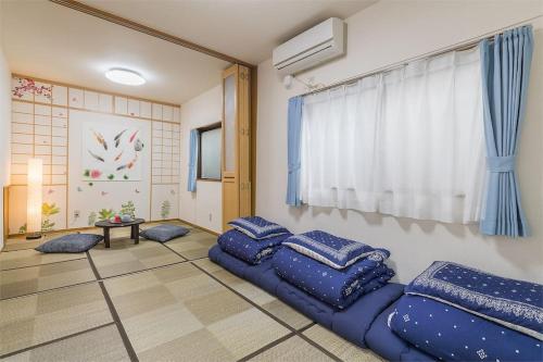 een woonkamer met blauwe kussens op de vloer bij Shinjuku12min Shibuya15min Max10ppi Free-Wifi in Tokyo