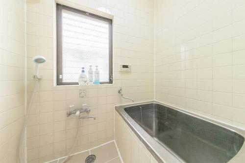 a bathroom with a tub and a window and a sink at Shinjuku12min Shibuya15min Max10ppi Free-Wifi in Tokyo