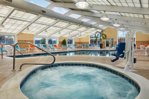 a hot tub in a hotel with chairs and tables at Holiday Inn - Gulfport-Airport by IHG in Gulfport