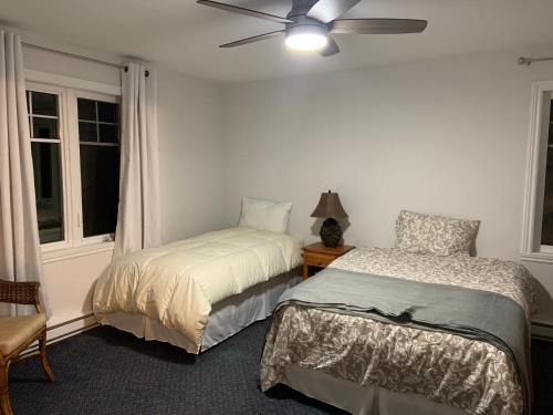 a bedroom with two beds and a ceiling fan at Condo Lac Archambault 316 in Saint-Donat-de-Montcalm