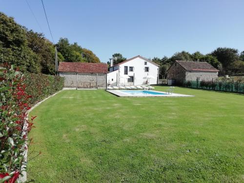 a yard with a house and a swimming pool at BUELIÑA DA CARBALLEIRA in Teo