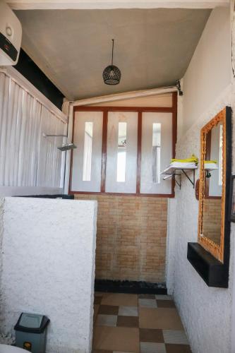 a room with a mirror and a window and a wall at BALI AMED FEEL HOME VILLA in Amed