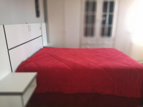 um quarto com uma cama vermelha e uma cómoda branca em Residência El Shaday em Gramado