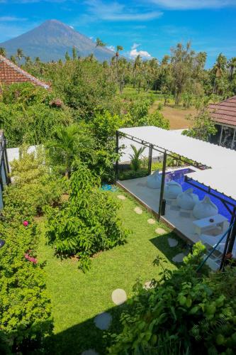a garden with a swimming pool and mountains in the background at BALI AMED FEEL HOME VILLA in Amed