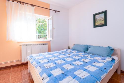 una camera con un letto blu e bianco e una finestra di Apartments with swimming pool Opatija - Pobri, Opatija - 16390 a Matulji (Mattuglie)