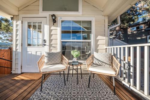 a porch with two chairs and a table at NEW! Boutique TinyHome w/Direct View of PikesPeak! in Woodland Park