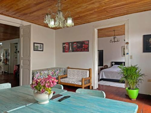 a living room with a table and a bedroom at Casa Madre Tierra SRC in Santa Rosa de Cabal