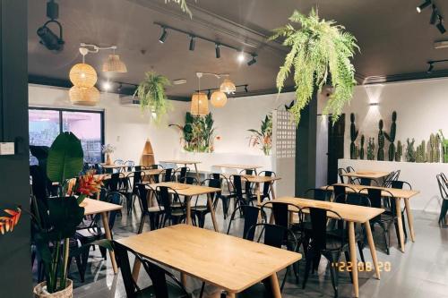 a restaurant with wooden tables and chairs and plants at TAMIM SUITE GROUP HOTEL Dungun in Dungun