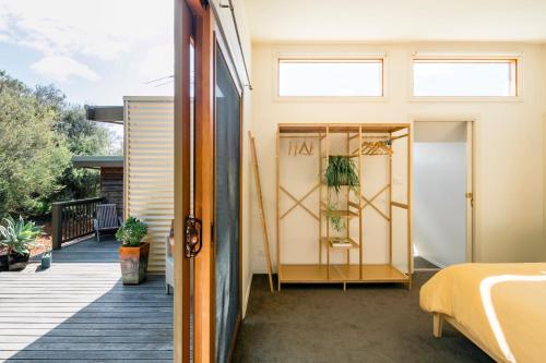 a home with a balcony with a door open at Birdsong Hideaway in Saint Andrews Beach