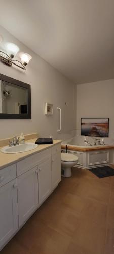 y baño con aseo, lavabo y bañera. en Condo Lac Archambault 305 en Saint-Donat-de-Montcalm