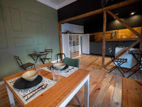 a dining room with a table with bowls and plates on it at Inn Door 21 - Hostel & Suite in Bragança