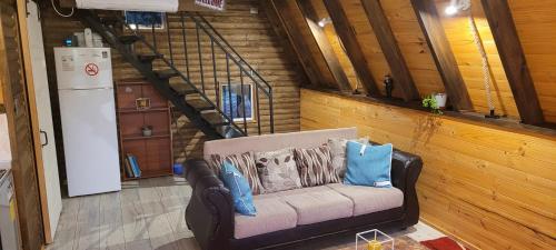 ein Wohnzimmer mit einem Sofa mit Kissen darauf in der Unterkunft Cabaña Alpina para 2 en Puerto Varas in Puerto Varas