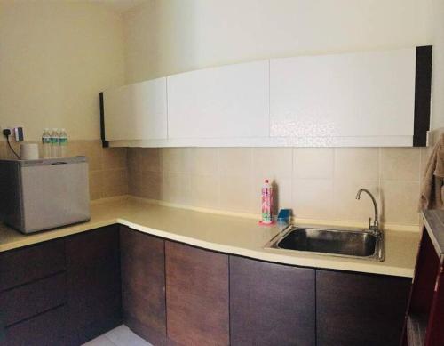 a kitchen with a sink and a refrigerator at Gold Coast Morib Seaview 2 rooms Aircond Apartment in Banting