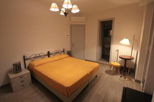 um quarto com uma cama, uma mesa e um candeeiro em Hotel B&B Francesca em Varazze