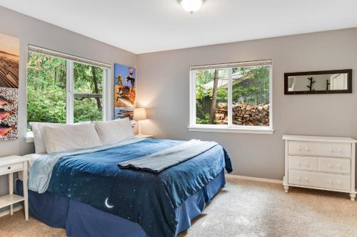 een slaapkamer met een bed en 2 ramen bij Reef Point Retreat in La Conner