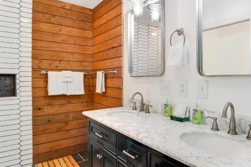 een badkamer met 2 wastafels en een houten muur bij Reef Point Retreat in La Conner