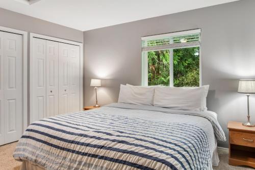 a bedroom with a bed with a striped blanket and a window at Reef Point Retreat in La Conner