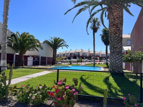 a resort with a swimming pool and palm trees at Genial Casa en Bahía Inglesa in Bahia Inglesa