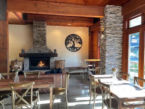 a restaurant with a fireplace and tables and chairs at Bridgehouse Lodge in Warkworth
