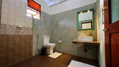 a bathroom with a toilet and a sink and a shower at Sea Pink Residence in Bentota